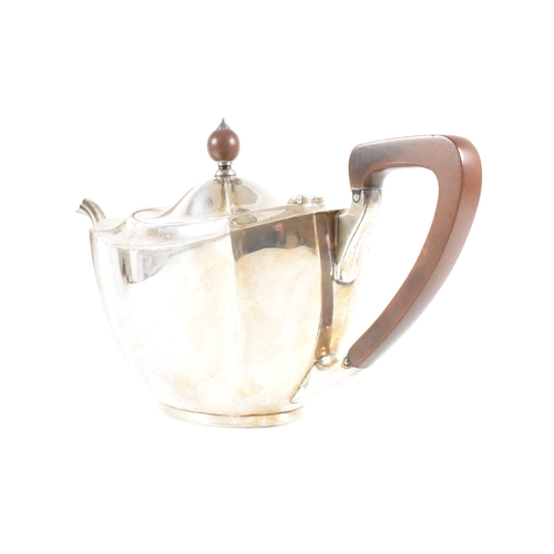 23 - A 1930s hallmarked silver tea pot. The George V tea pot sitting on an oval plinth base raising to a ... 