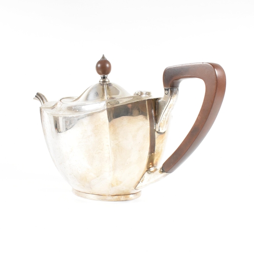 23 - A 1930s hallmarked silver tea pot. The George V tea pot sitting on an oval plinth base raising to a ... 