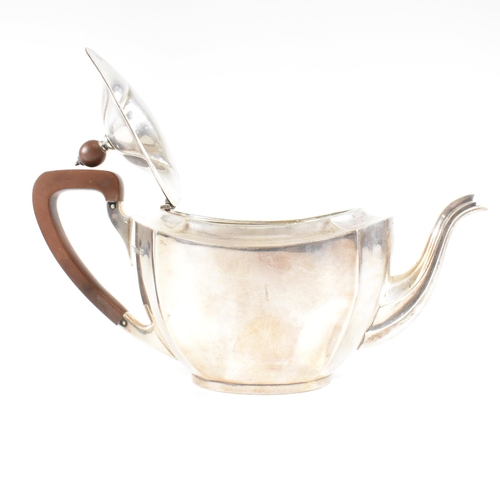 23 - A 1930s hallmarked silver tea pot. The George V tea pot sitting on an oval plinth base raising to a ... 