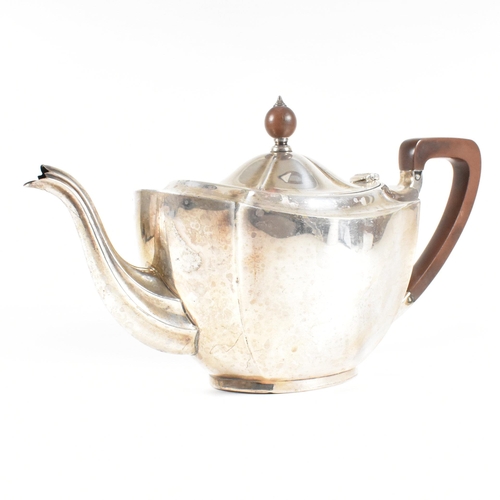 23 - A 1930s hallmarked silver tea pot. The George V tea pot sitting on an oval plinth base raising to a ... 