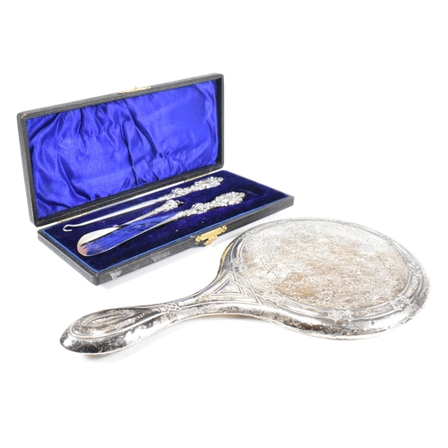 24 - An early 20th Century hallmarked silver vanity mirror and cased set of silver handled items. The lot... 