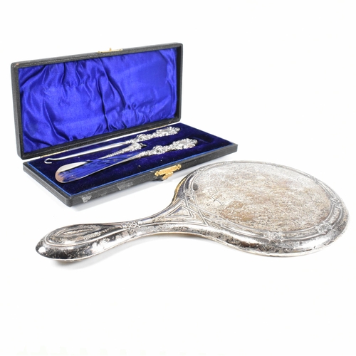 24 - An early 20th Century hallmarked silver vanity mirror and cased set of silver handled items. The lot... 