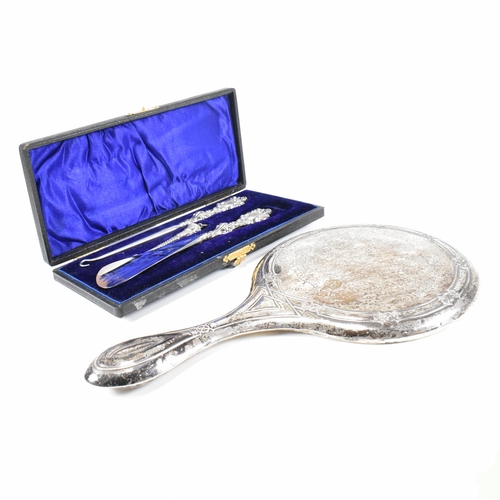 24 - An early 20th Century hallmarked silver vanity mirror and cased set of silver handled items. The lot... 