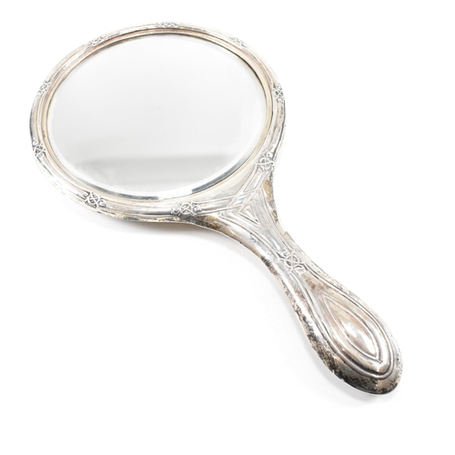 24 - An early 20th Century hallmarked silver vanity mirror and cased set of silver handled items. The lot... 