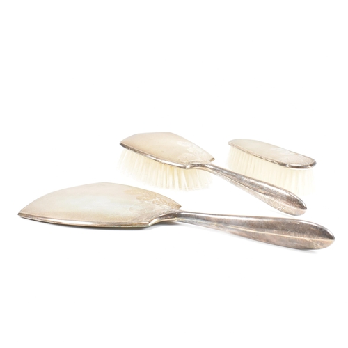 27 - A 1970s Vintage hallmarked silver three piece vanity set. The set having an engine turned finish wit... 