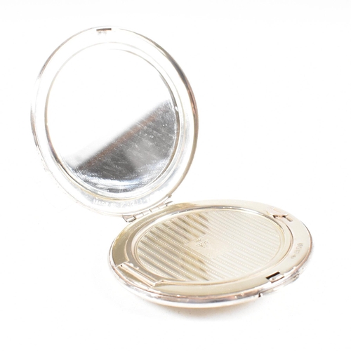 44 - A Mid century hallmarked silver compact. The compact being of circular form with hinged opening and ... 