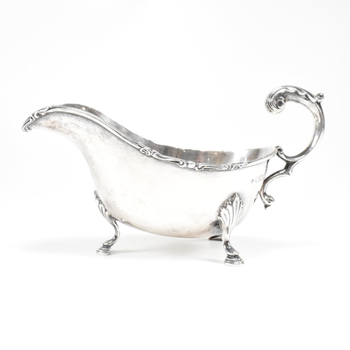 46 - A George V hallmarked silver sauce boat. The sauce or gravy boat having three hoof feet raising to a... 