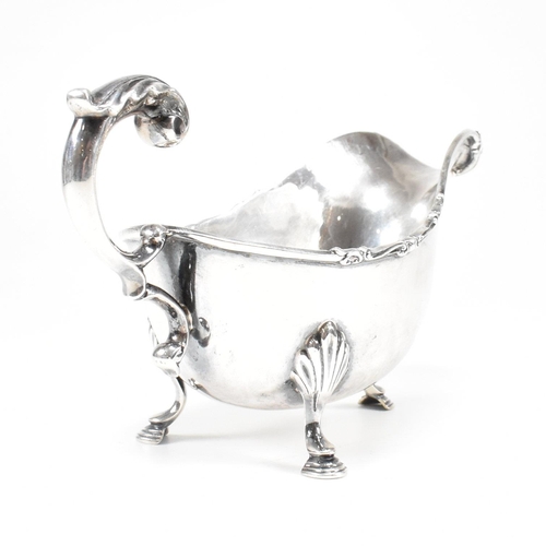 46 - A George V hallmarked silver sauce boat. The sauce or gravy boat having three hoof feet raising to a... 