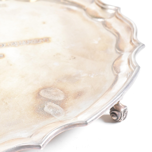 48 - A mid century hallmarked silver salver. The salver having four hoof feet rising to tray with stepped... 