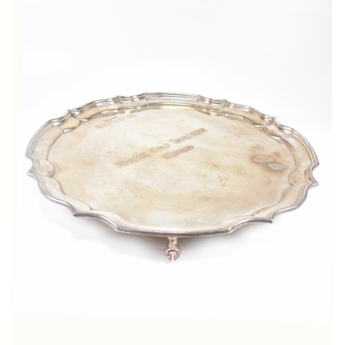 48 - A mid century hallmarked silver salver. The salver having four hoof feet rising to tray with stepped... 