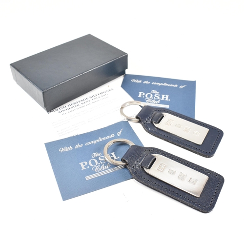 55 - Two 1990s hallmarked silver and leather tag keyrings. The silver tags backed with navy blue leather ... 