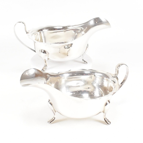 77 - A pair of mid-centuryÿ hallmarked silver sauce boats. The pair having three hoof feet rising to jugu... 