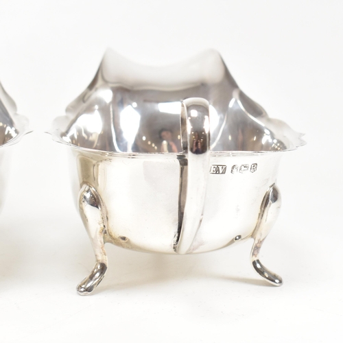 77 - A pair of mid-centuryÿ hallmarked silver sauce boats. The pair having three hoof feet rising to jugu... 