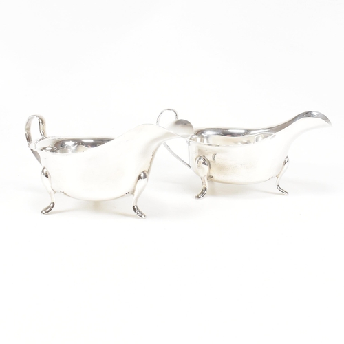 77 - A pair of mid-centuryÿ hallmarked silver sauce boats. The pair having three hoof feet rising to jugu... 