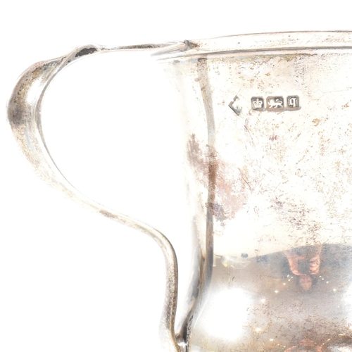 84 - George V hallmarked silver trophy cup. The cup having a circular stepped plinth base raising to a bu... 