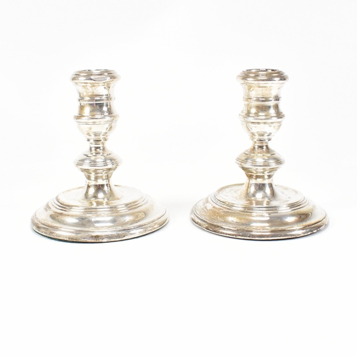 91 - A pair ofÿ mid-century hallmarked silver squat candlesticks. The candlesticks having a weighted base... 