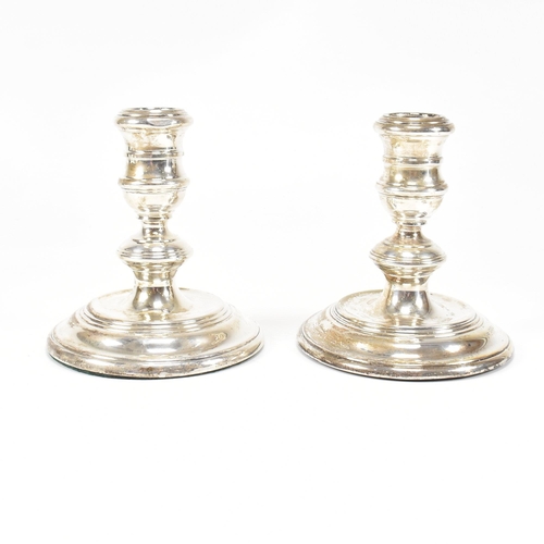 91 - A pair ofÿ mid-century hallmarked silver squat candlesticks. The candlesticks having a weighted base... 