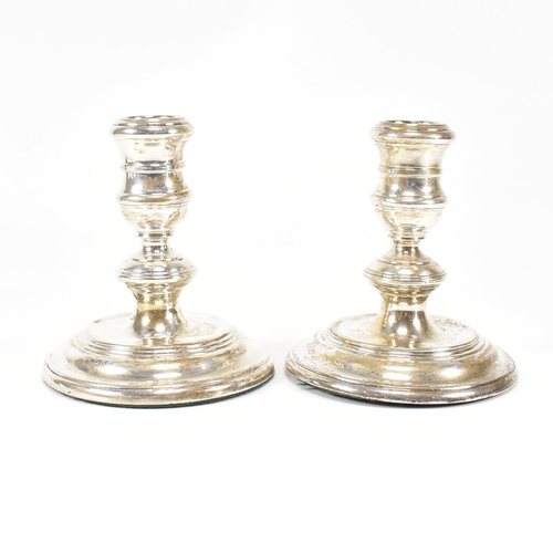 91 - A pair ofÿ mid-century hallmarked silver squat candlesticks. The candlesticks having a weighted base... 