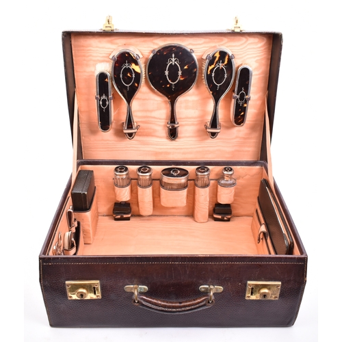 210 - A 1920s hallmarked silver and tortoiseshell leather cased travelling vanity set. The suite to includ... 