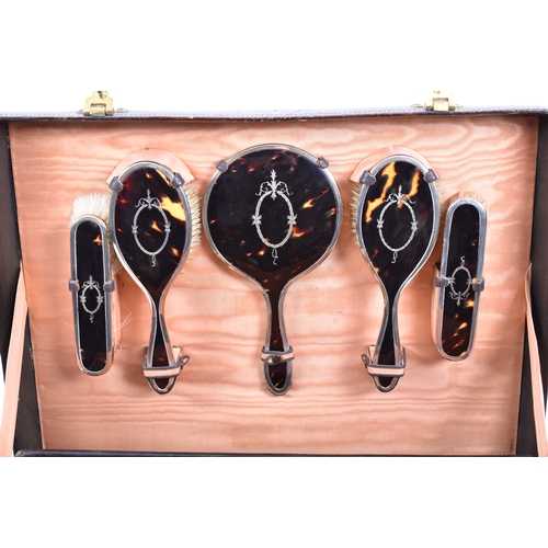 210 - A 1920s hallmarked silver and tortoiseshell leather cased travelling vanity set. The suite to includ... 