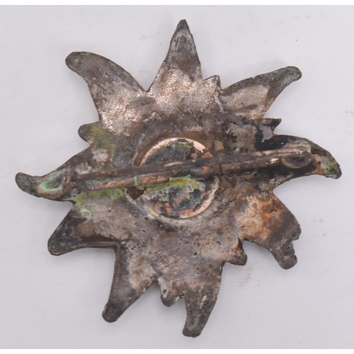 302 - A WWII Second World War Third Reich Nazi German Ski badge. Edelweiss flower shape with a black ename... 