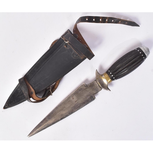 333 - A vintage Indian made dagger with a leather leg holster. The dagger with a round white metal pommel,... 