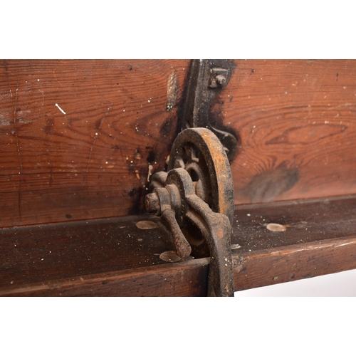 141 - An early 20th century solid pine & cast iron ecclesiastic church bench pew. The bench having a recta... 