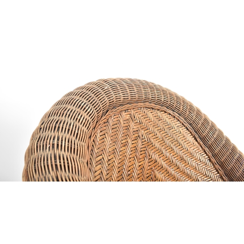 158 - A 20th century rattan and wicker framed conservatory armchair. The chair with deep scrolled back and... 