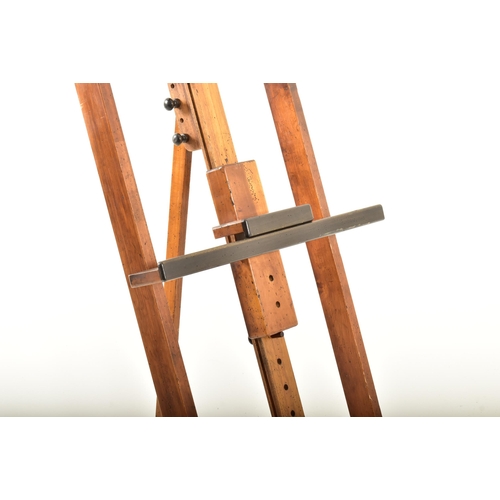 217 - A large vintage late 20th century wooden artist's easel. The easel having adjustable canvas holder a... 