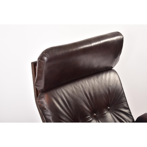 237 - A retro 20th century Danish teak and leather armchair. Tall padded backrest cushioned seat rest with... 