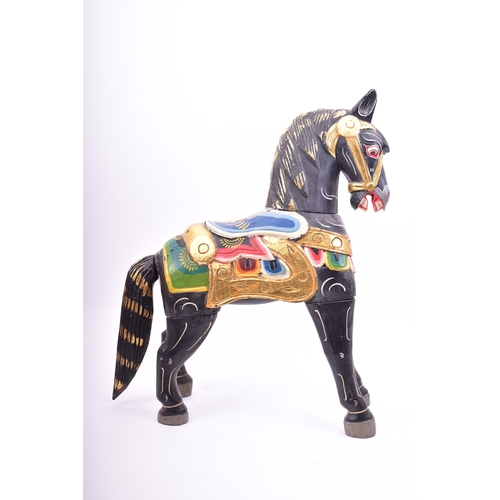 257 - A mid 20th century hand painted Indian style wooden toy horse. The horse black, with gilt highlights... 