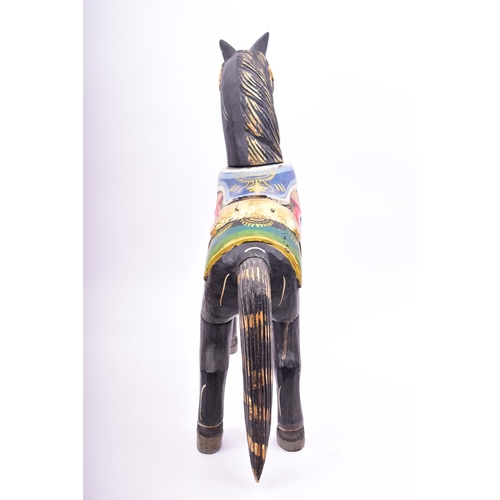 257 - A mid 20th century hand painted Indian style wooden toy horse. The horse black, with gilt highlights... 