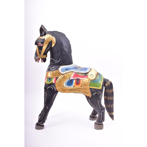 257 - A mid 20th century hand painted Indian style wooden toy horse. The horse black, with gilt highlights... 