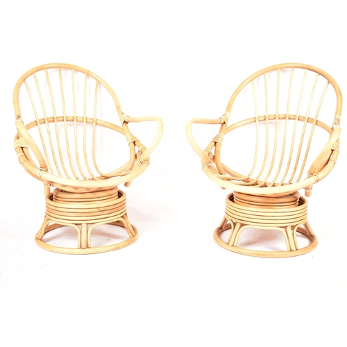 298 - A pair of retro 20th century bamboo and wicker / cane swivel armchair / egg chairs. Each chair havin... 