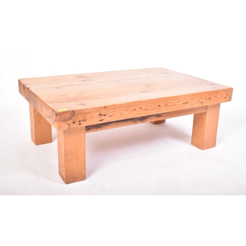 302 - A vintage 20th century railway sleeper pine coffee table / low table. The table having a pine top co... 