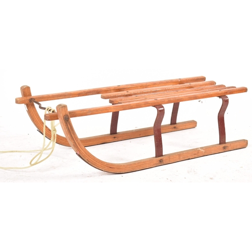 335 - A pair of vintage 20th century wooden & metal sleighs / sleds. Each with bent fronts and metal suppo... 