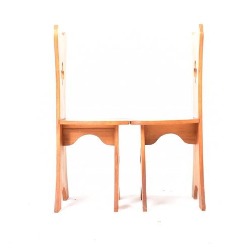 336 - A matching pair of 20th century carved pine chairs. Each with shaped backrests and central carved cl... 