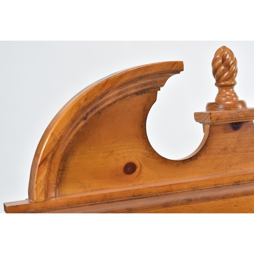 342 - A vintage 20th century American pine hanging mirror. The mirror having a carved pediment top with ce... 