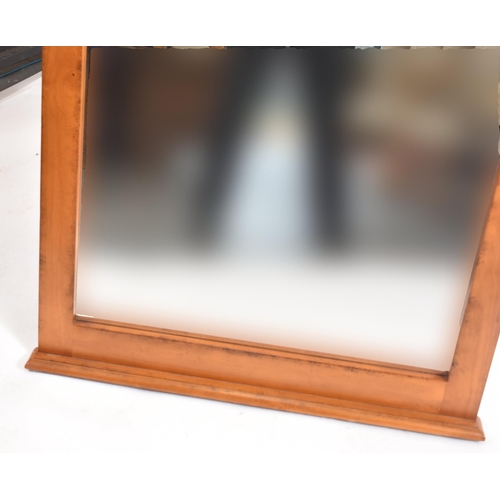 342 - A vintage 20th century American pine hanging mirror. The mirror having a carved pediment top with ce... 