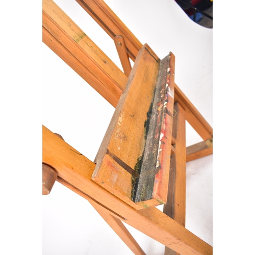 366 - A vintage 20th century oak artist easel. The easel being adjustable raised on trestle supports unite... 