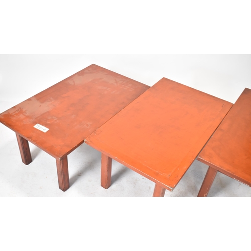 378 - A group of three 20th century red lacquered coffee / low tables. Each table having a rectangular top... 