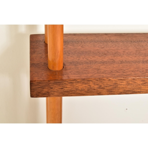 459 - A contemporary stained beech wood peg jointed wall hanging shelf unit. The unit having three tiers w... 