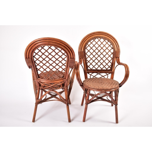 474 - A matching set of four 20th century wicker and rattan woven dining chairs / armchairs. Each chair ha... 