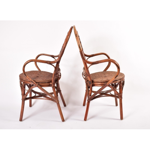 474 - A matching set of four 20th century wicker and rattan woven dining chairs / armchairs. Each chair ha... 