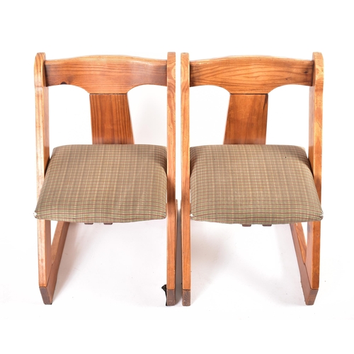 609 - A matching pair of 20th century pine framed chairs. Each chair having a yoke top rails with central ... 