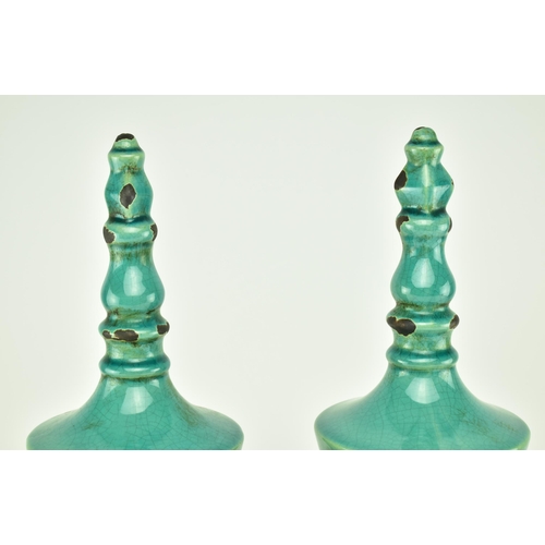 233 - A pair of turquoise / green crackle glazed urn style home interior decorative objects. Largest measu... 