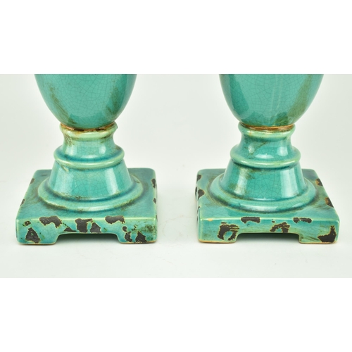 233 - A pair of turquoise / green crackle glazed urn style home interior decorative objects. Largest measu... 