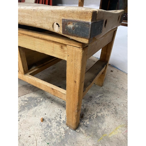 17 - An early 20th century large iron bound butcher's block. Raised on a chucky pine base set with a sing... 