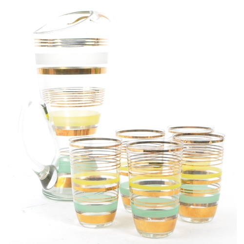 31 - A vintage 20th century glass lemonade set. Comprising of a tapering jug with flared lip and carry ha... 