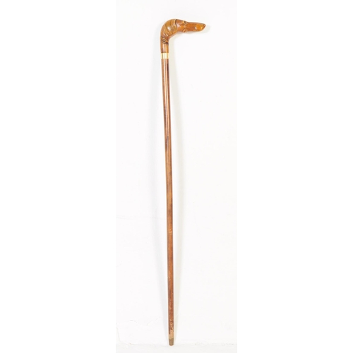 363 - A 20th century walking stick having handle carved in the from of a dogs head with amber glass bead e... 